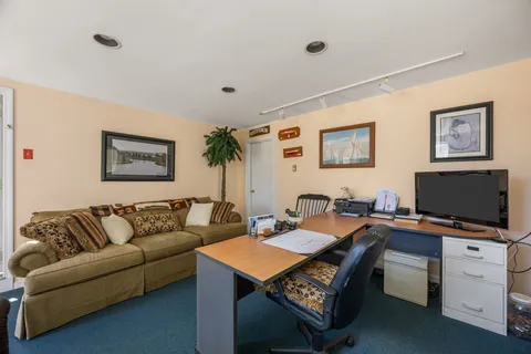 a view of a livingroom with an empty space & a window