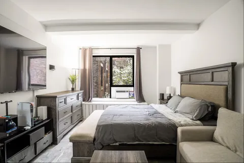 a bedroom with a large bed and a window