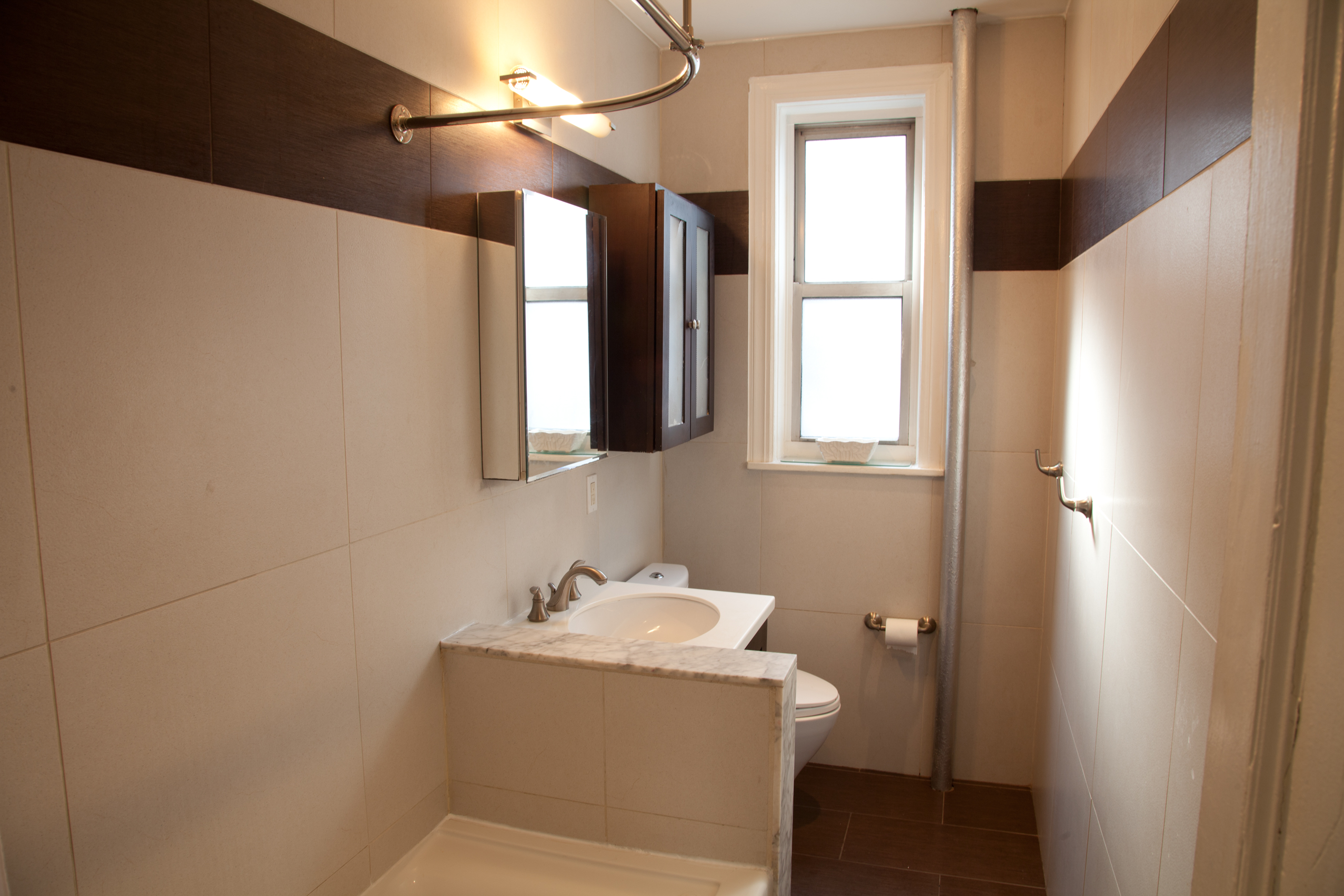 2022 Beverley Road, Unit 7 Brooklyn, NY 11226 - Photo 8 of 10 a bathroom with a sink and mirror with window