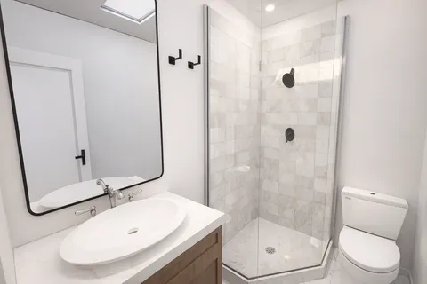 a bathroom with a sink a toilet and shower