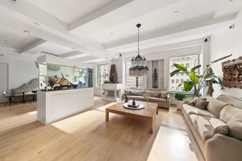 a living room with furniture kitchen view and a large window