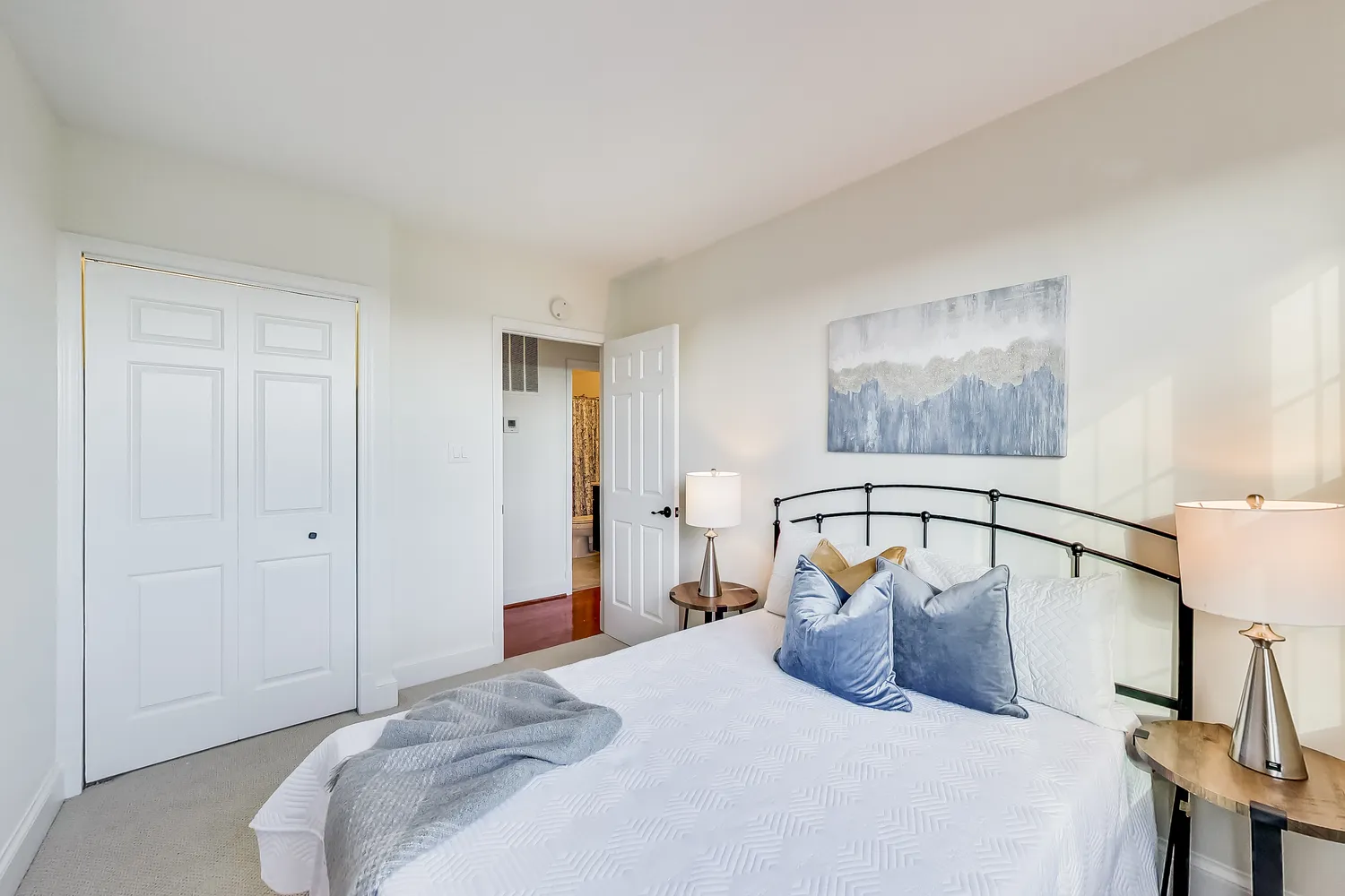 a bedroom with a bed and a painting on the wall