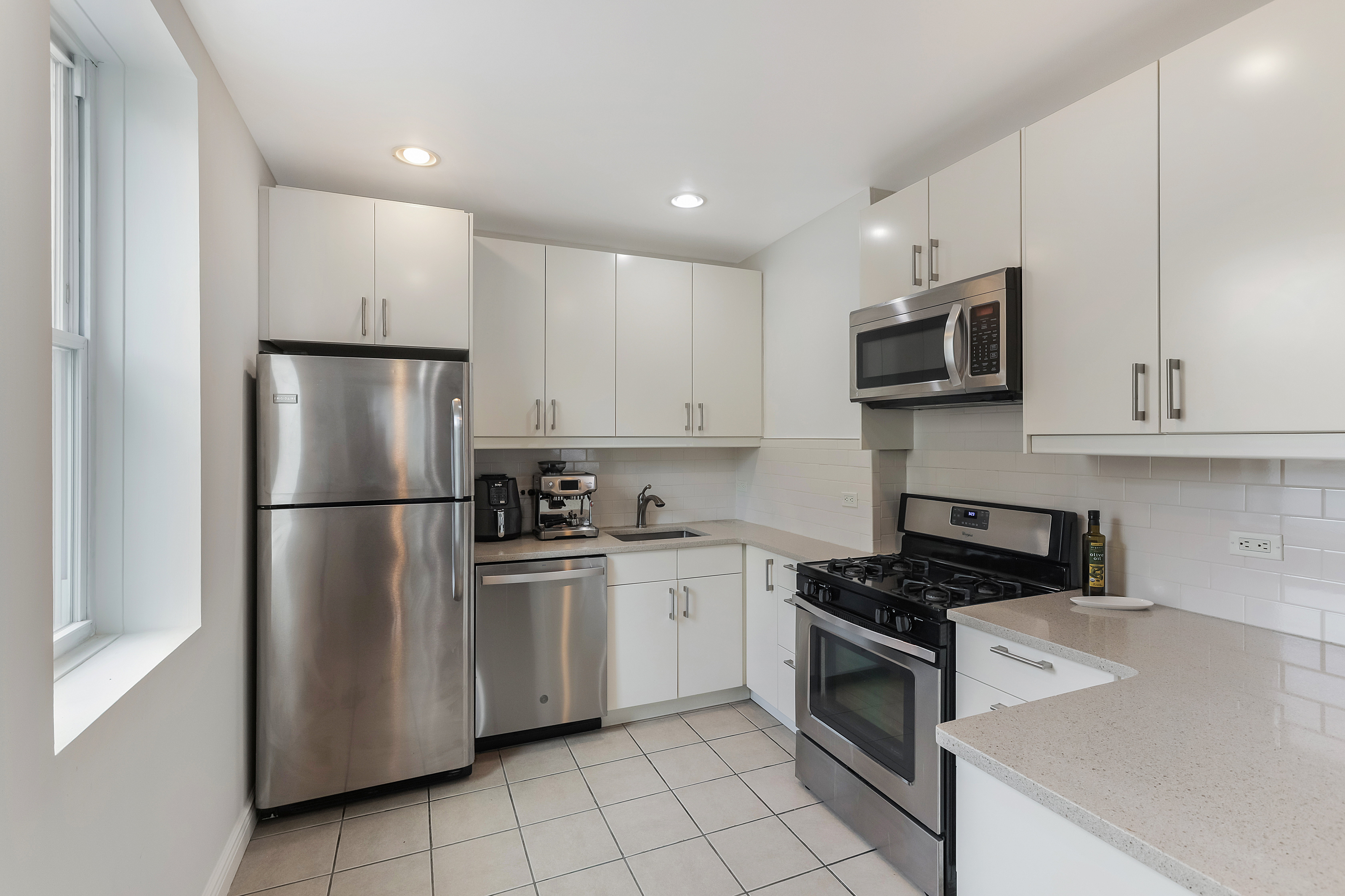 89 Wyckoff Street, Unit 4B Brooklyn, NY 11201 - Photo 3 of 9 a kitchen with stainless steel appliances granite countertop white cabinets a refrigerator a stove a microwave oven and a sink with granite countertops