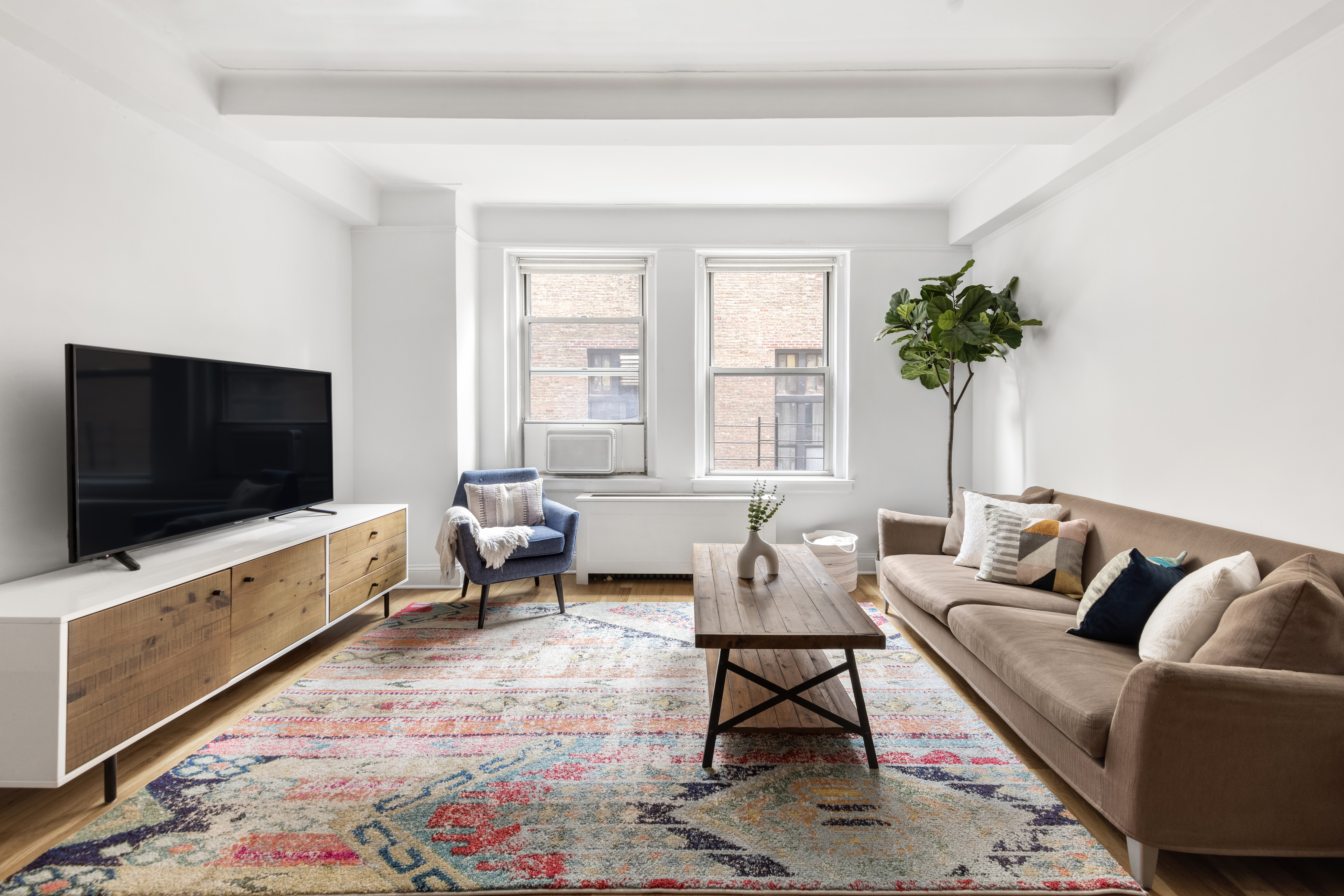 425 East 86th Street, Unit 2F Manhattan, NY 10028 - Photo 2 of 11 a living room with furniture and a flat screen tv