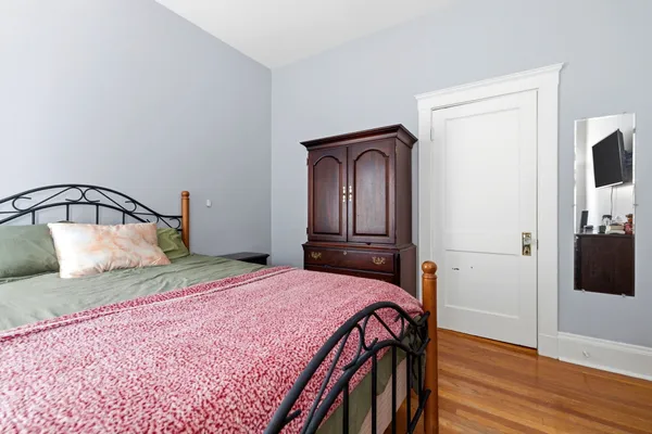 a bedroom with a bed and wooden floor