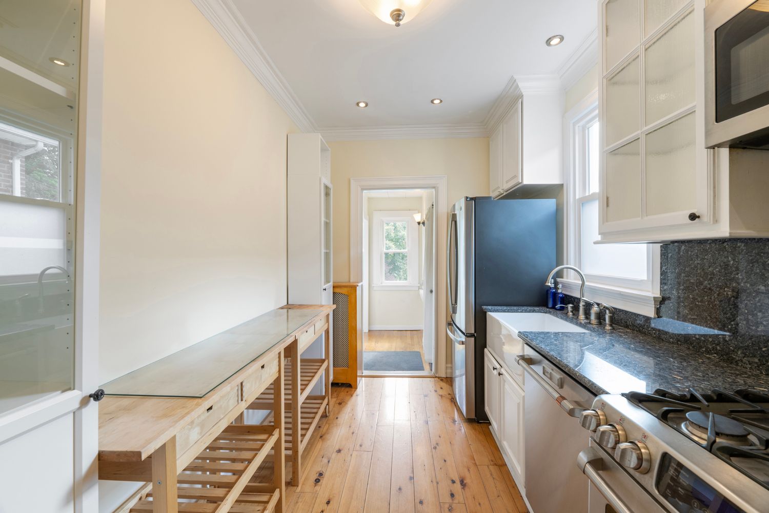 a kitchen with stainless steel appliances a refrigerator a stove and wooden floor