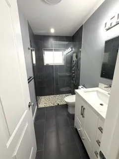 a bathroom with a granite countertop sink toilet and shower