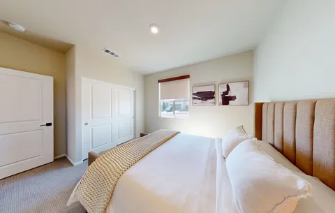 a bedroom with a bed and a lamp on dresser