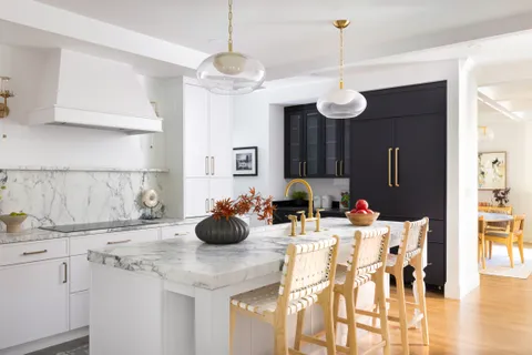 a kitchen with a sink a chandelier and living room view