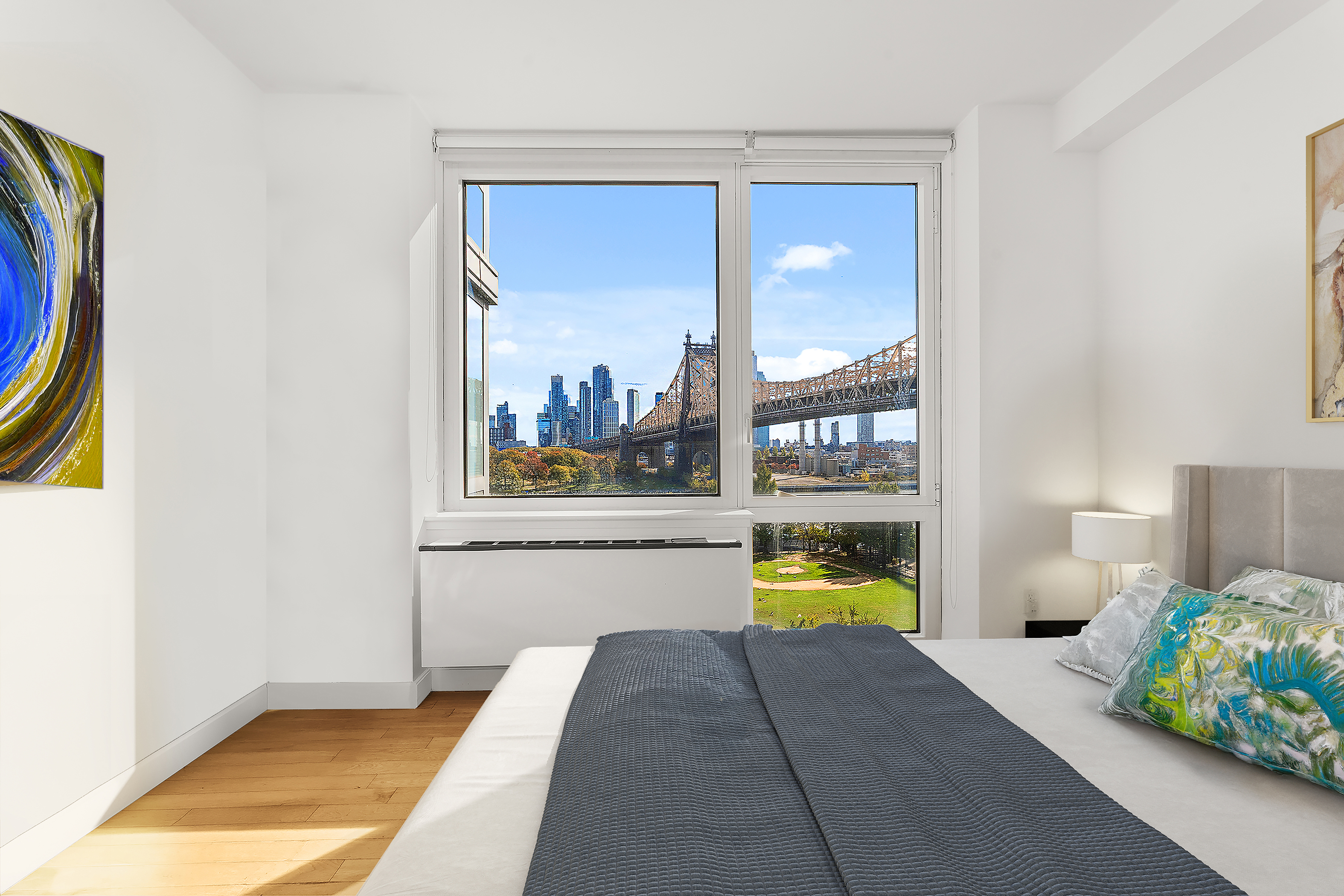 415 Main Street, Unit 7C Manhattan, NY 10044 - Photo 3 of 16 a bedroom with a bed and a painting on the wall