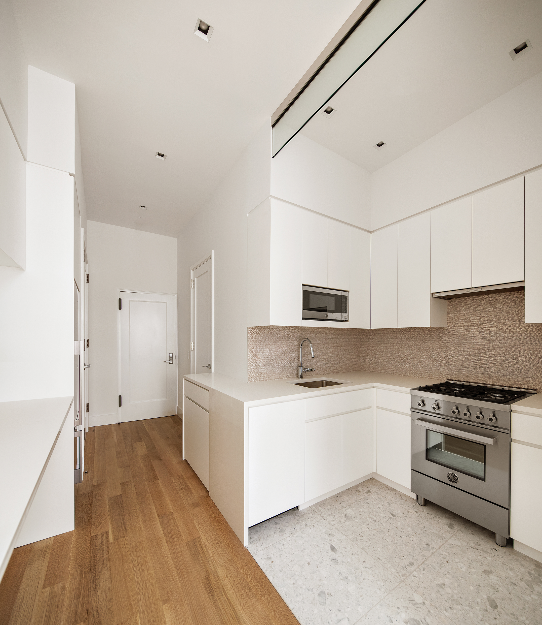 435 East 85th Street, Unit 4P Manhattan, NY 10028 - Photo 3 of 9 a kitchen with stainless steel appliances a sink a stove a microwave and cabinets