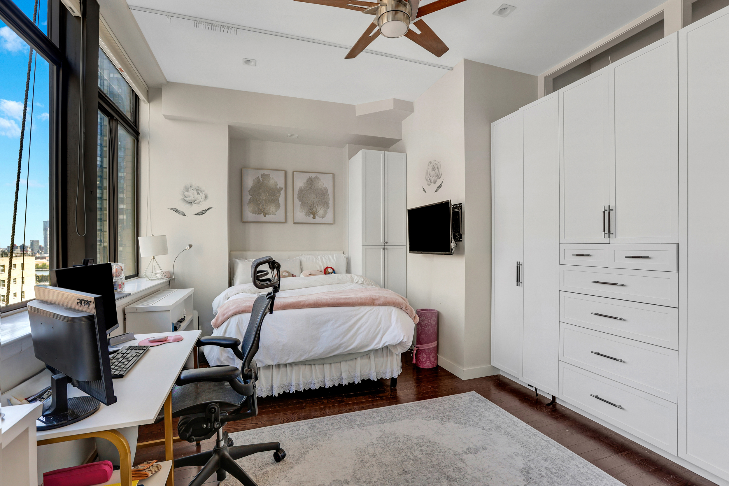 310 East 46th Street, Unit 16B Manhattan, NY 10017 - Photo 6 of 7 a bedroom with a bed and a flat tv screen