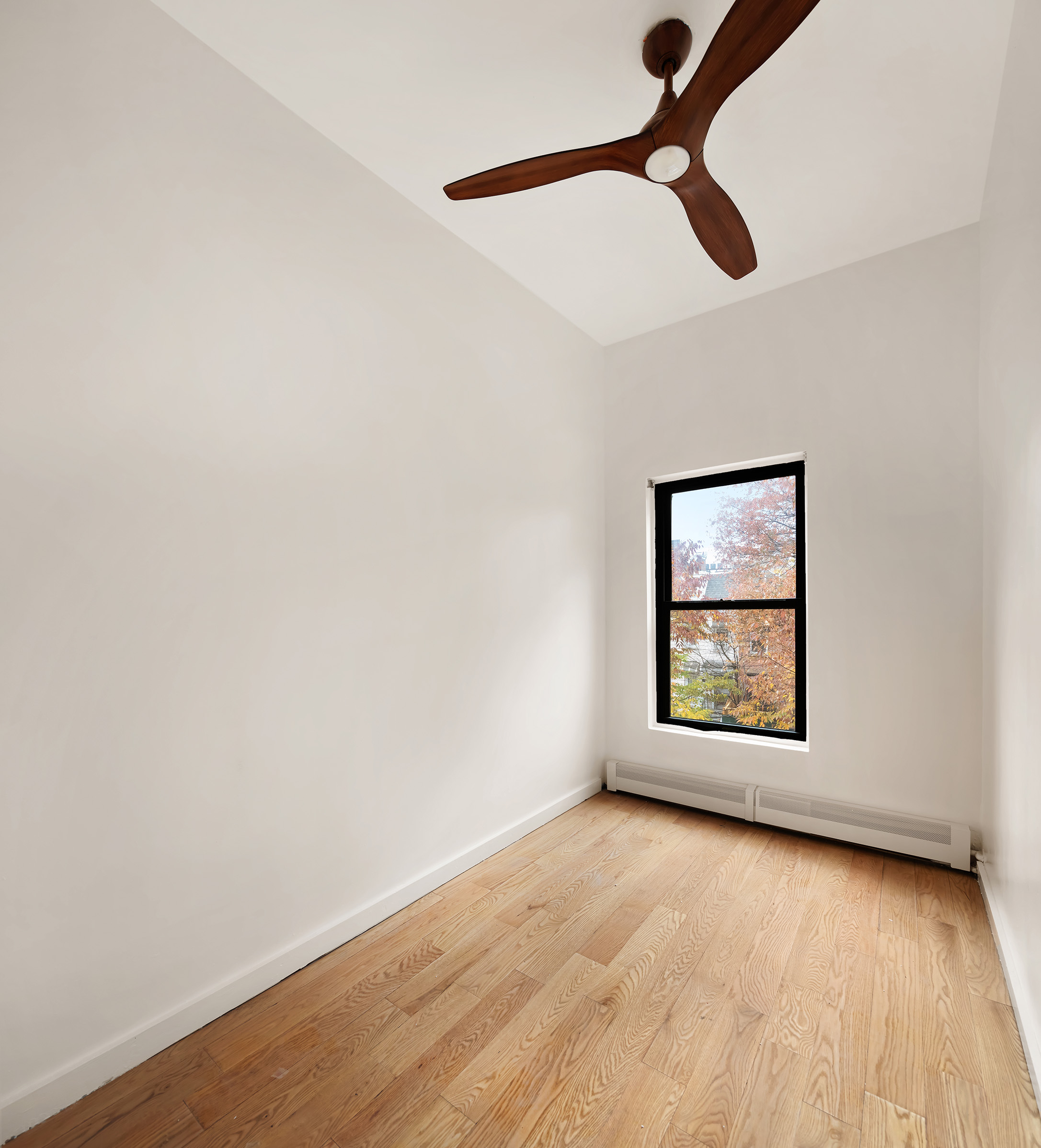 106 Monroe Street, Unit 2 Brooklyn, NY 11216 - Photo 4 of 6 a view of an empty room with window and wooden floor