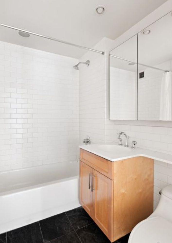 516 West 47th Street, Unit S4D Manhattan, NY 10036 - Photo 3 of 10 a bathroom with a sink a toilet and a bathtub