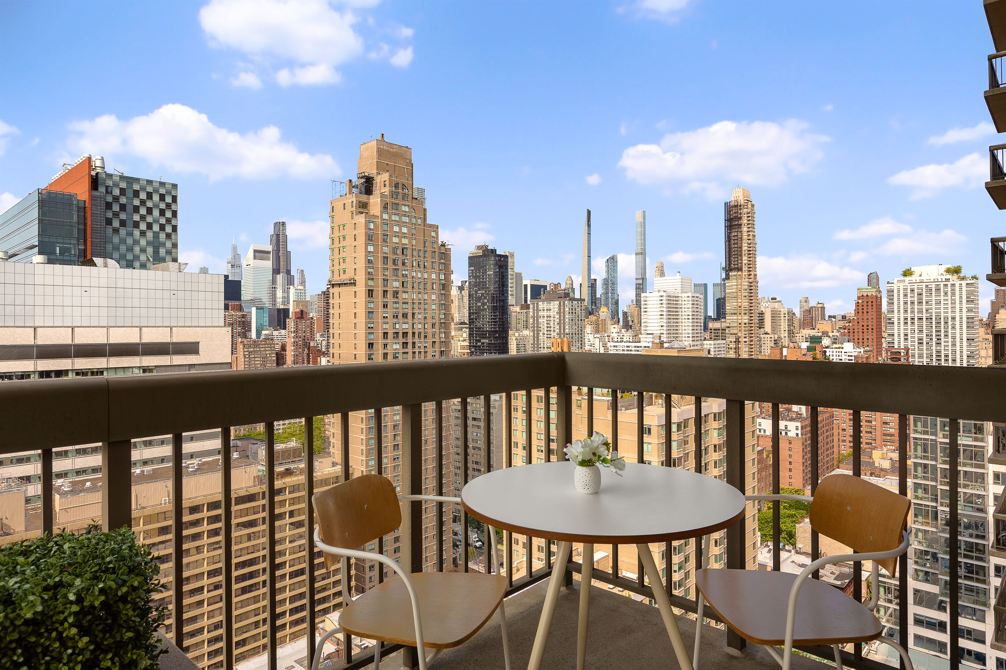 422 East 72nd Street, Unit 27C Manhattan, NY 10021 - Photo 5 of 25 a view of a balcony with a table and chairs and potted plants