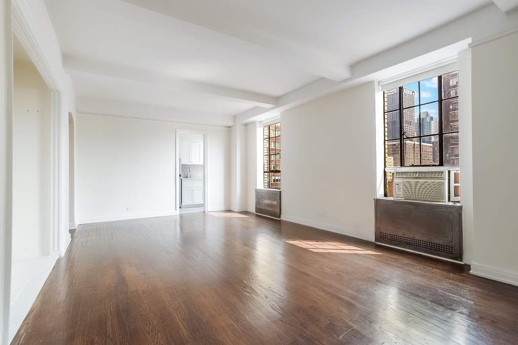 340 West 57th Street, Unit 14E Manhattan, NY 10019 - Photo 3 of 13 an empty room with wooden floor and windows