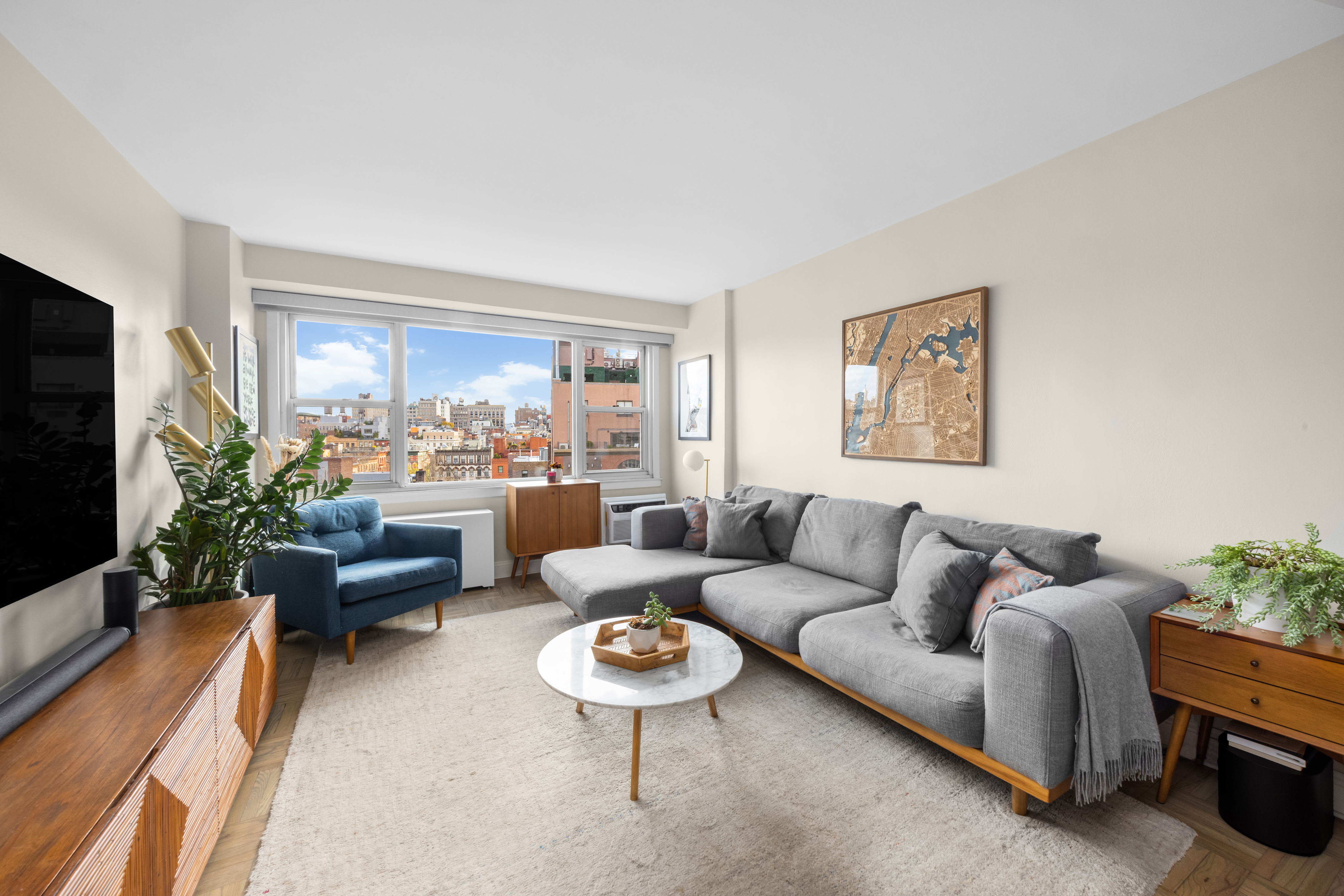 2 Charlton Street, Unit 10F Manhattan, NY 10014 - Photo 3 of 13 a living room with furniture and a flat screen tv