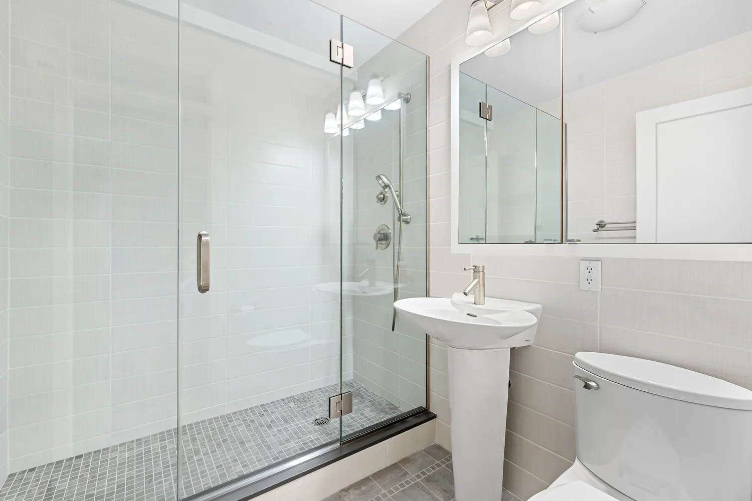 a bathroom with a sink a toilet and shower