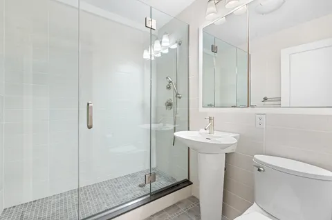 a bathroom with a sink a toilet and shower