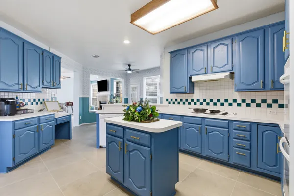 a kitchen with granite countertop a sink stove and cabinets