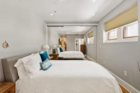 a bedroom with a bed and a large mirror