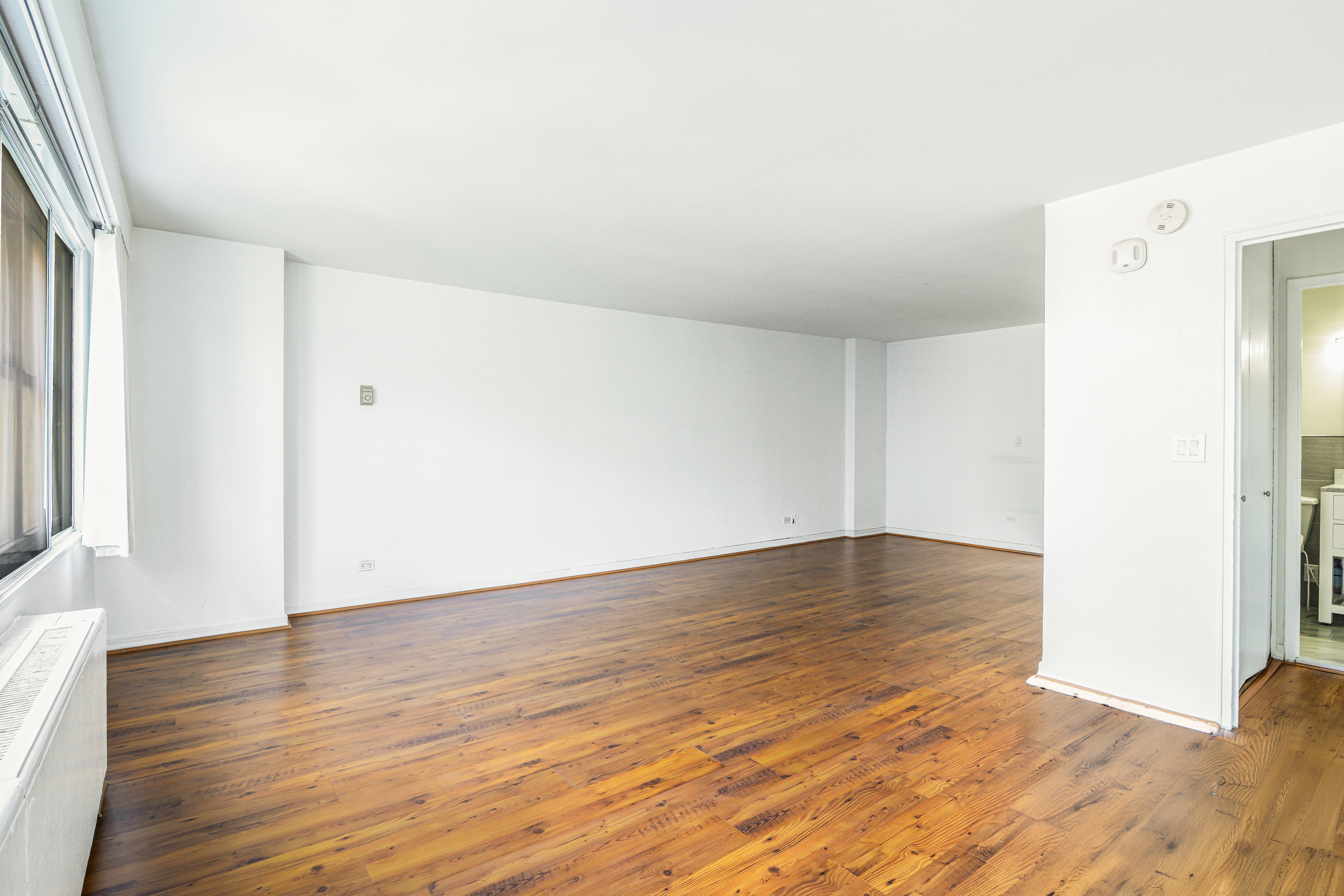 155 West 68th Street, Unit 1907 Manhattan, NY 10023 - Photo 6 of 20 a view of empty room with wooden floor