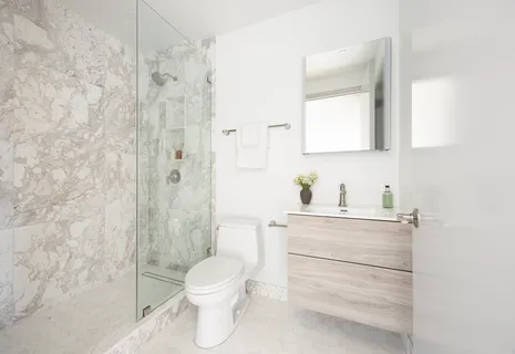 a bathroom with a sink a toilet and shower