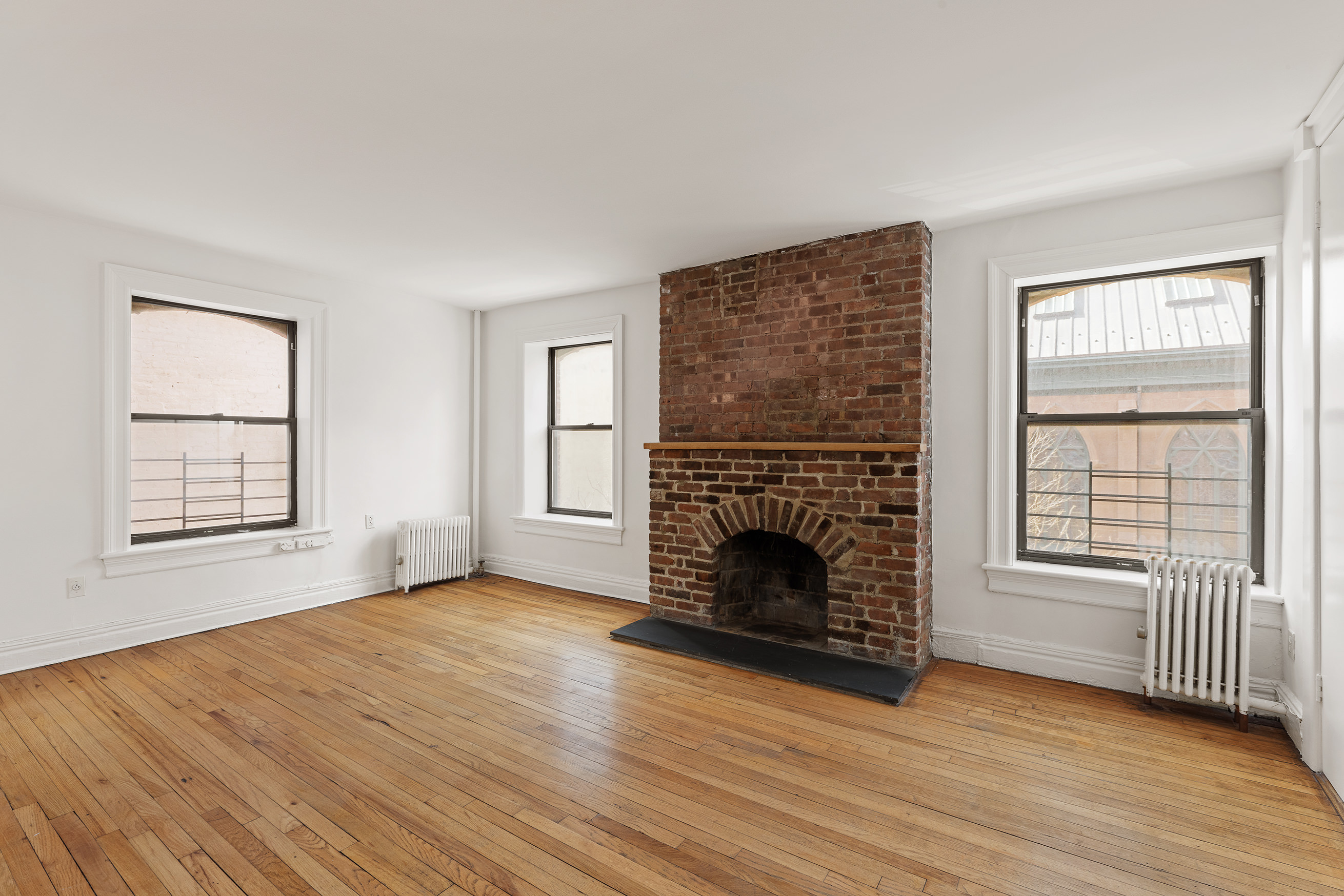 295 East 8th Street, Unit 2/3E Manhattan, NY 10009 - Photo 17 of 23 wooden floor fireplace and windows in an empty room