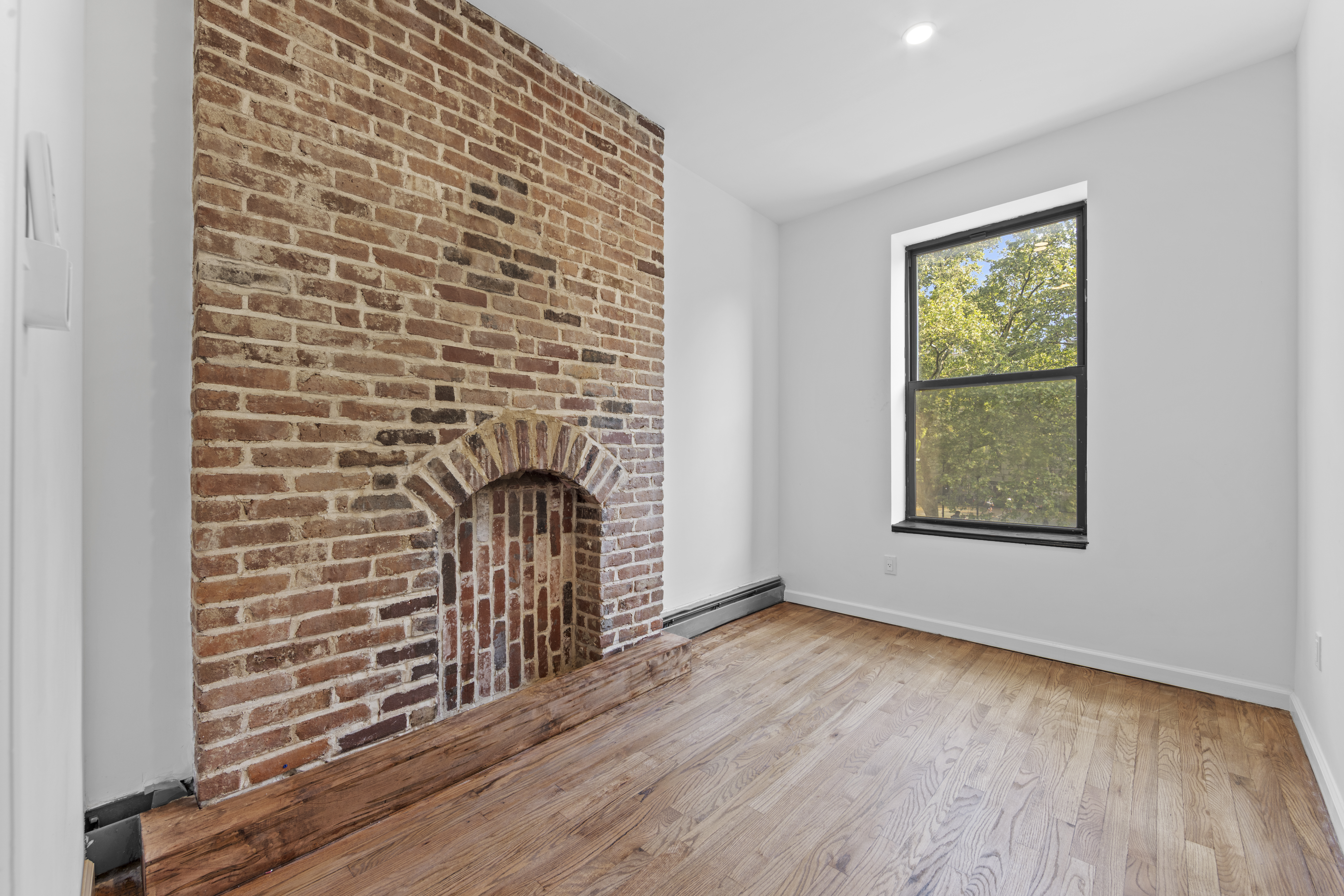 1061 Fulton Street, Unit 3 Brooklyn, NY 11238 - Photo 10 of 14 a view of an empty room with wooden floor and a window