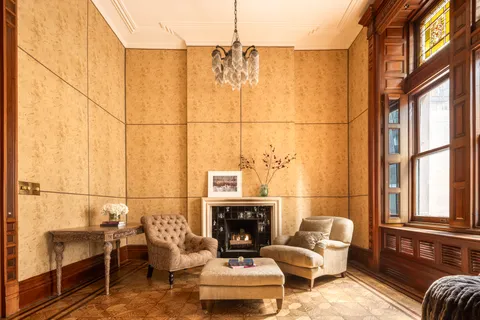 a living room with furniture a fireplace and a floor to ceiling window