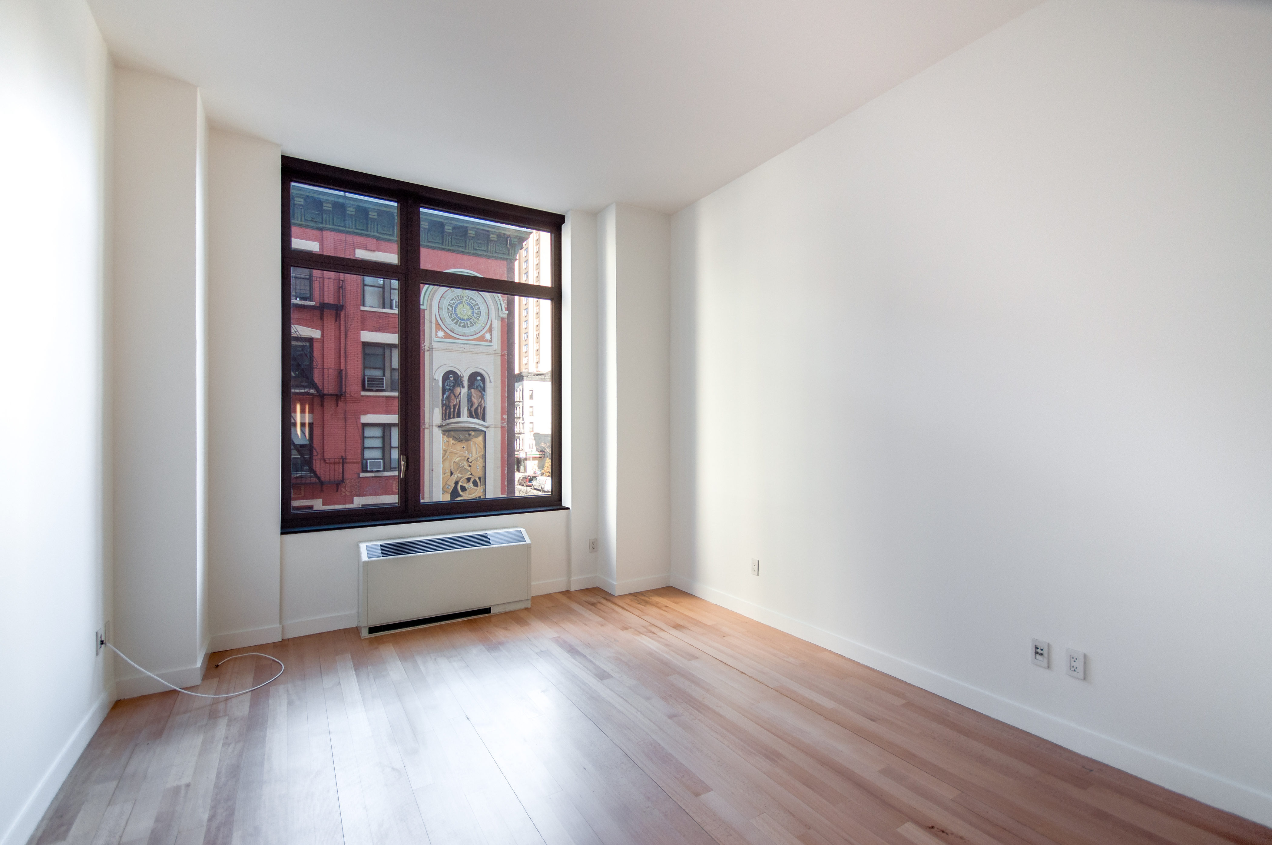 450 East 83rd Street, Unit 3D Manhattan, NY 10028 - Photo 2 of 15 an empty room with wooden floor and windows