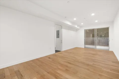 a view of empty room with wooden floor