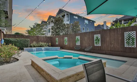 a view of a house with pool and sitting area
