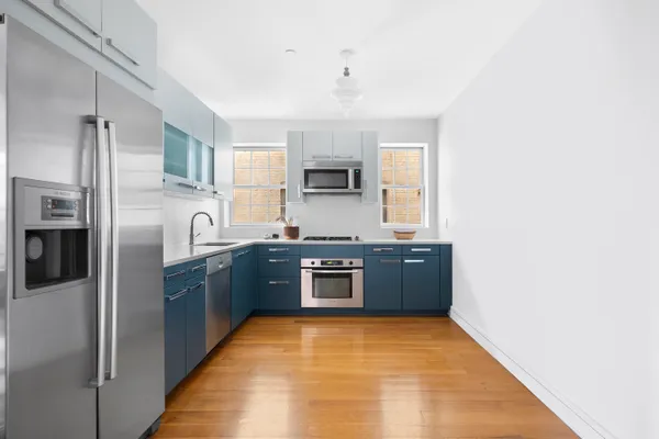 a kitchen with stainless steel appliances granite countertop a refrigerator and a stove