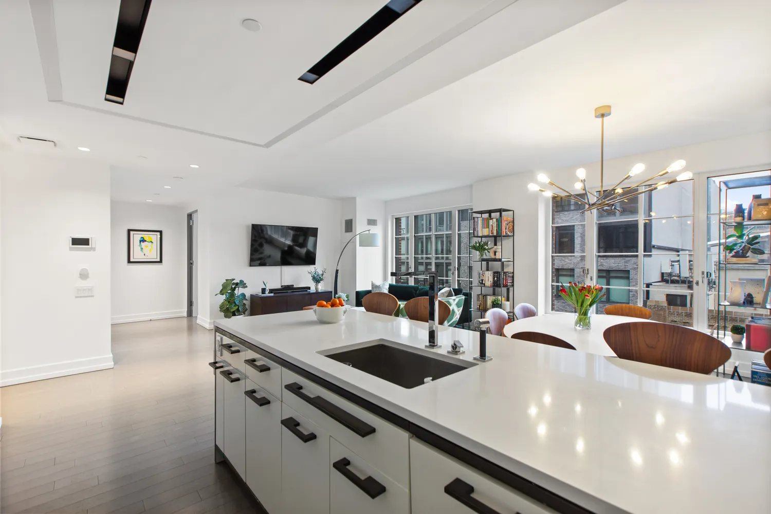 a kitchen with stainless steel appliances a sink a stove and a living room view