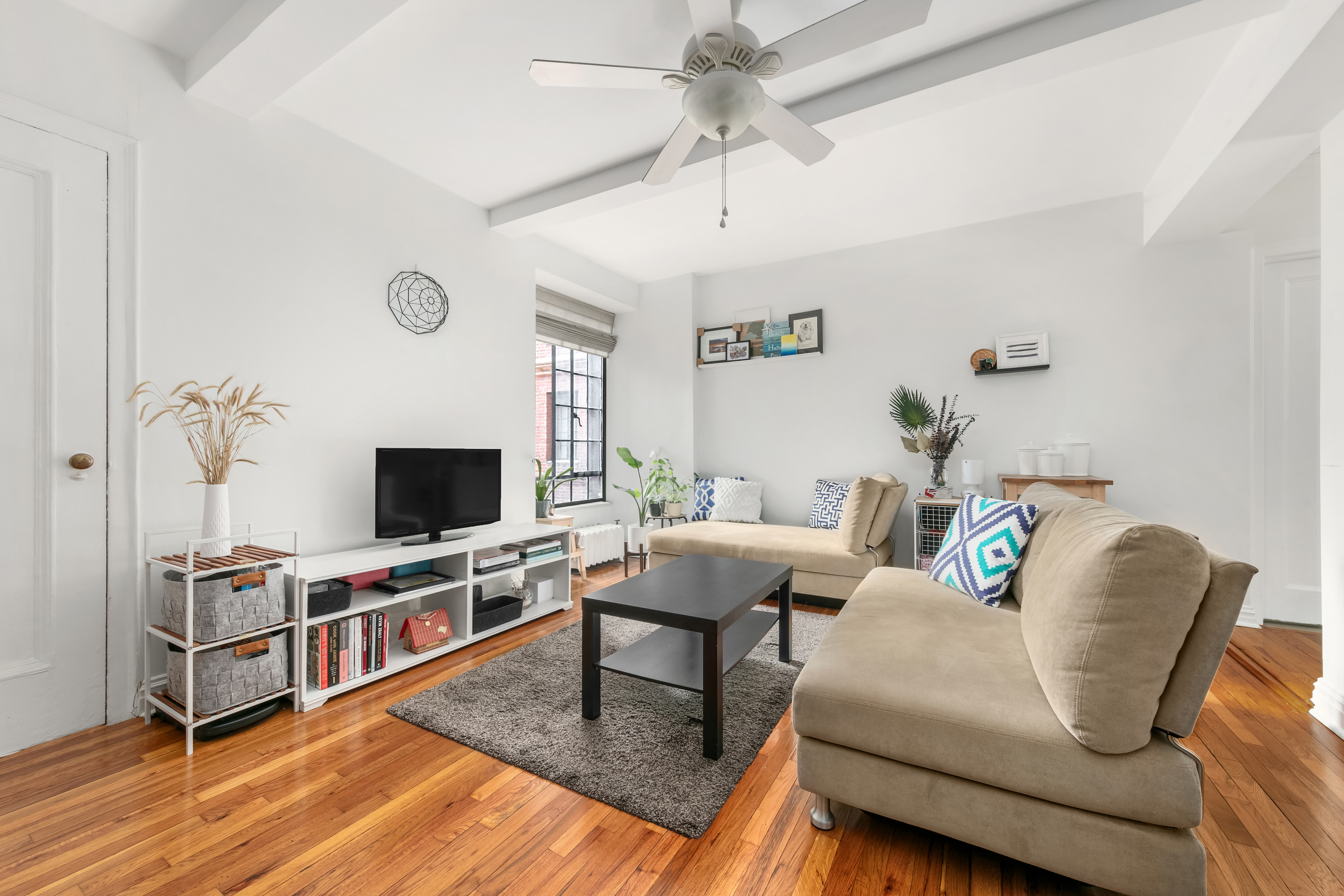 333 East 43rd Street, Unit 311 Manhattan, NY 10017 - Photo 2 of 18 a living room with furniture and a flat screen tv