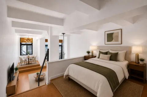a bedroom with bed and a flat tv screen on dresser