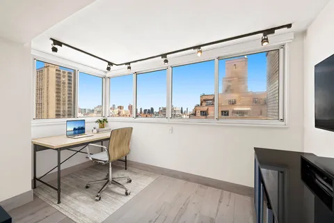 a room with a window a desk and chair