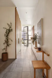 a hallway with a table and a potted plant