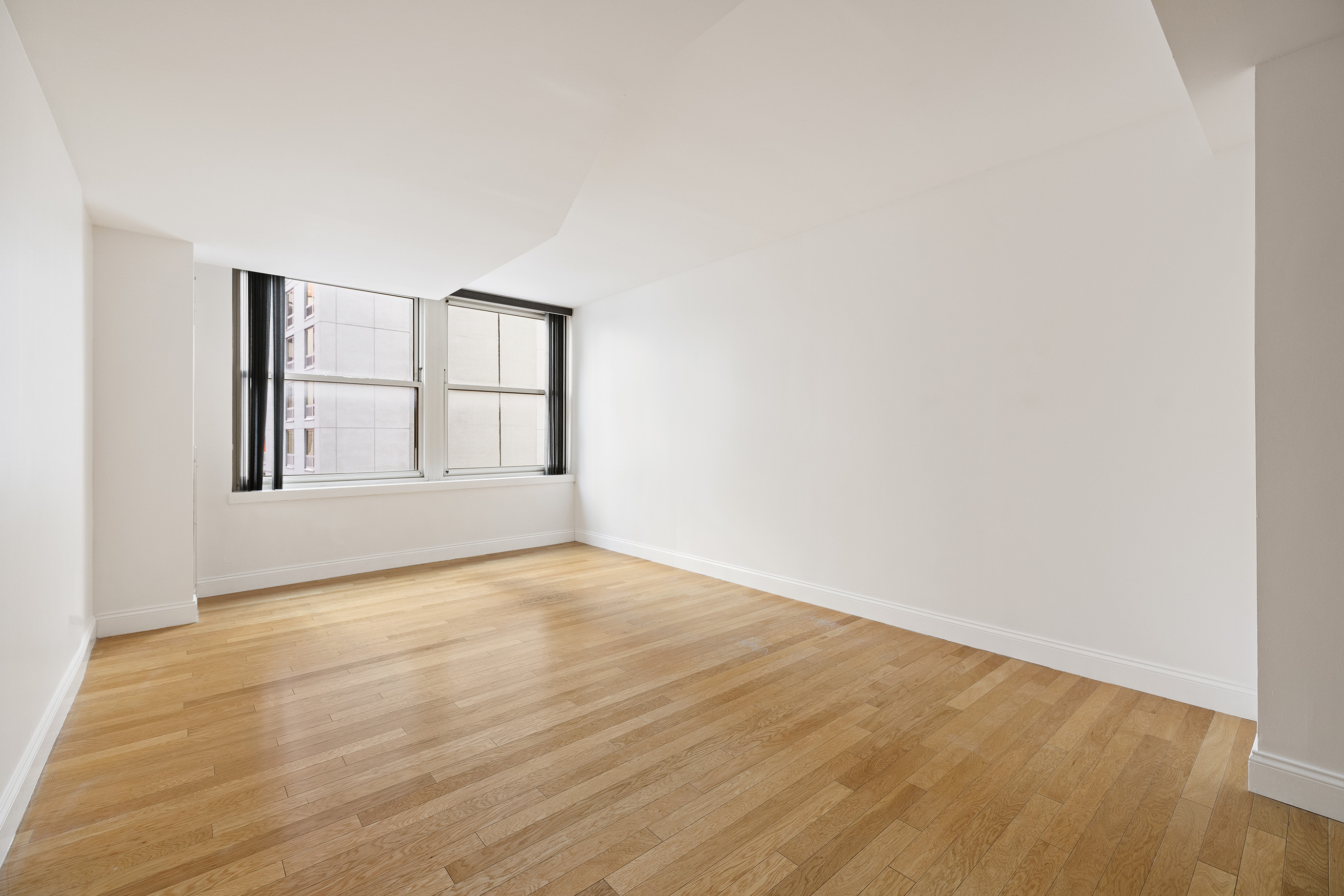 88 Greenwich Street, Unit 1014 Manhattan, NY 10006 - Photo 8 of 14 an empty room with wooden floor and windows