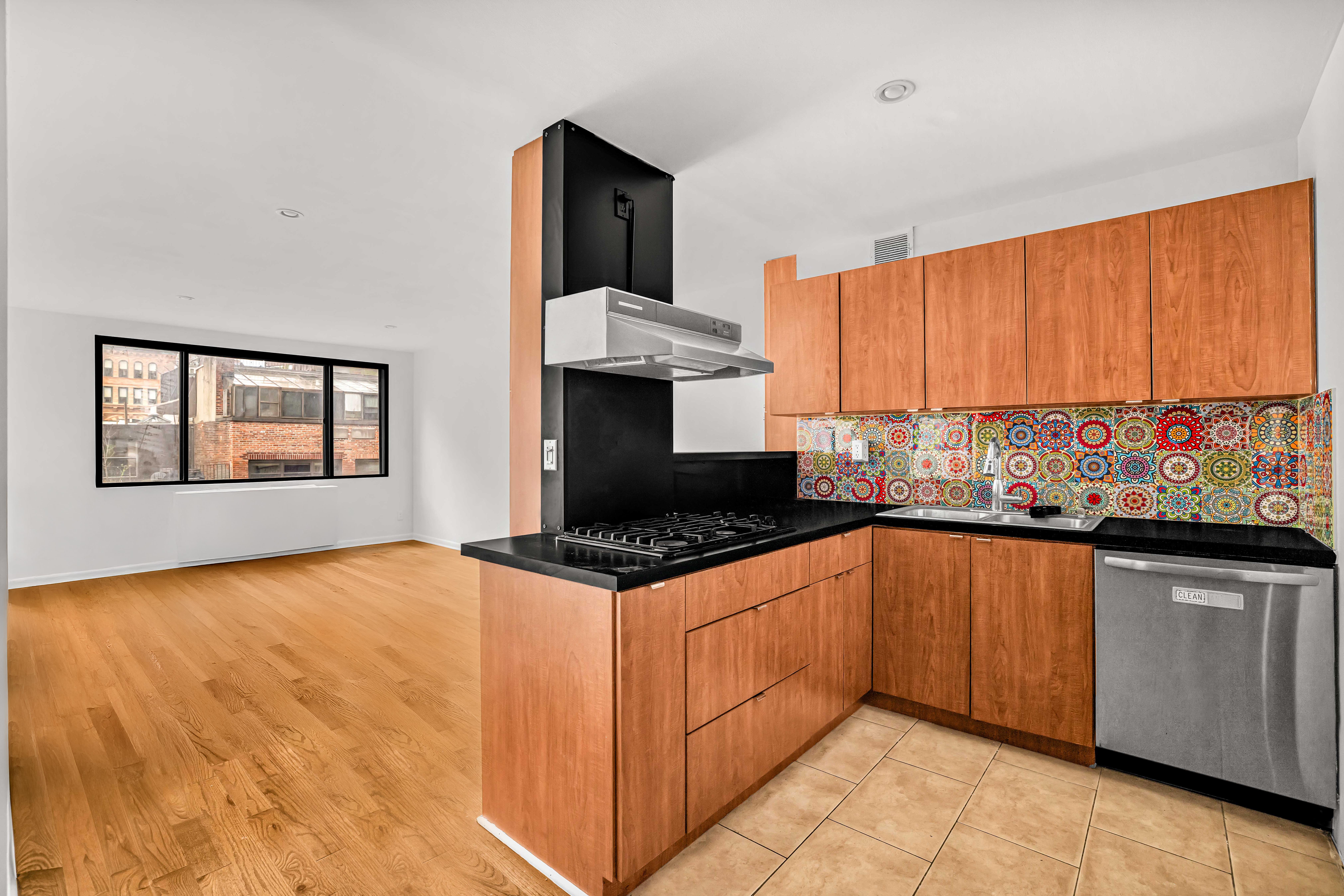 44 East 12th Street, Unit 8E Manhattan, NY 10003 - Photo 2 of 7 a kitchen with stainless steel appliances granite countertop a stove a sink and a microwave