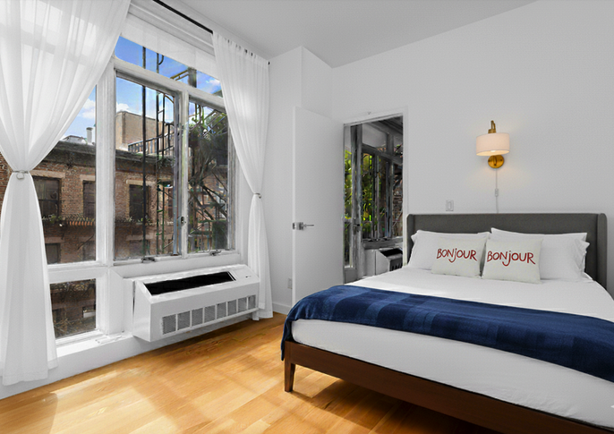 342 East 110th Street, Unit 3D Manhattan, NY 10029 - Photo 12 of 15 a bedroom with a bed and a large window