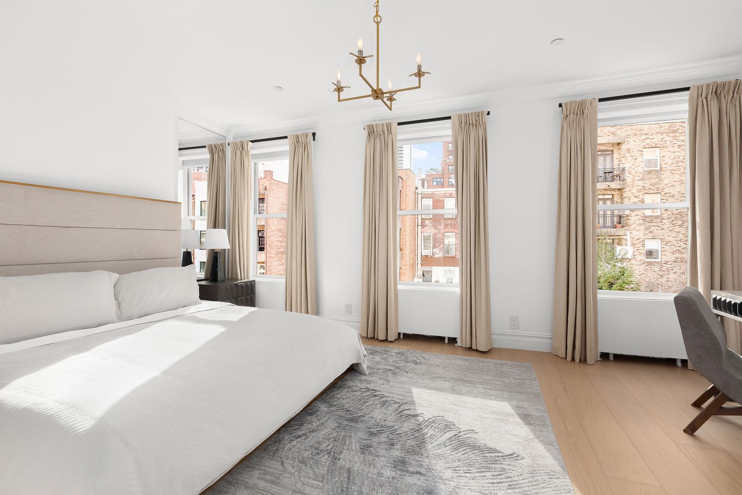 222 East 61st Street Manhattan, NY 10065 - Photo 16 of 28 a bedroom with a bed and large windows