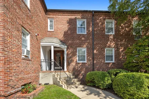 front view of a brick house with a small yard