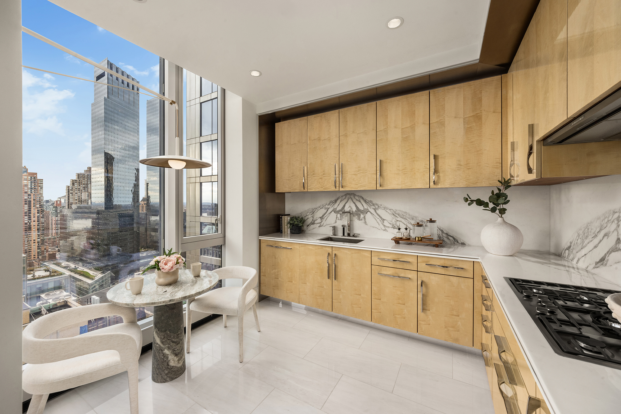 217 West 57th Street, Unit 34F Manhattan, NY 10019 - Photo 5 of 25 a kitchen with granite countertop a sink stove and cabinets