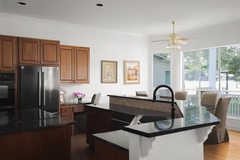 a kitchen with a table chairs a refrigerator and a stove