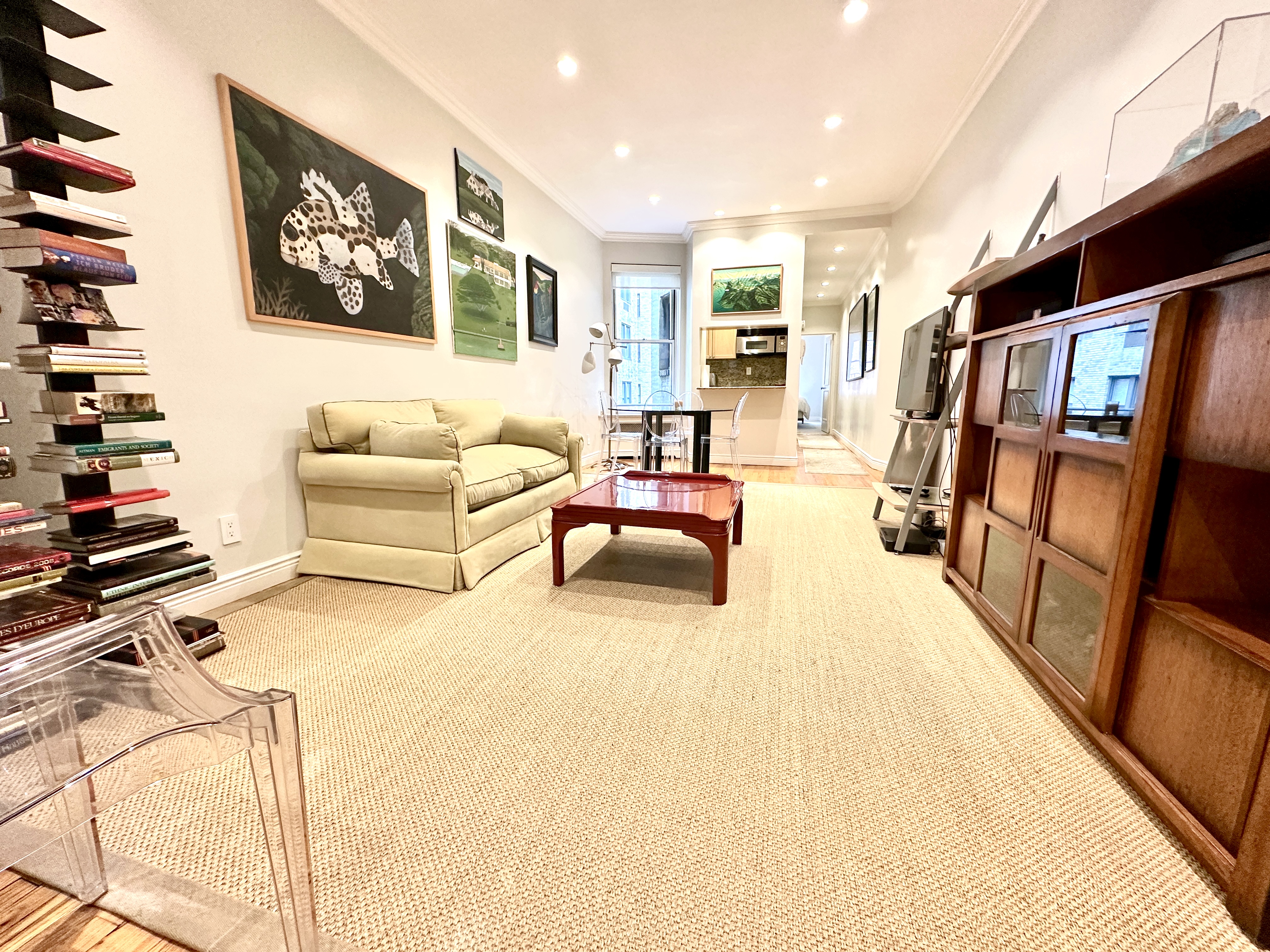20 East 88th Street, Unit 5B Manhattan, NY 10128 - Photo 1 of 8 a bedroom with furniture and a book shelf