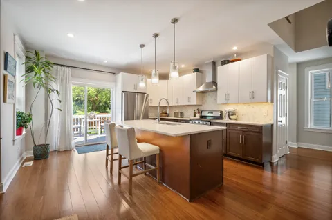 a kitchen with stainless steel appliances granite countertop wooden floor sink stove and wooden floor