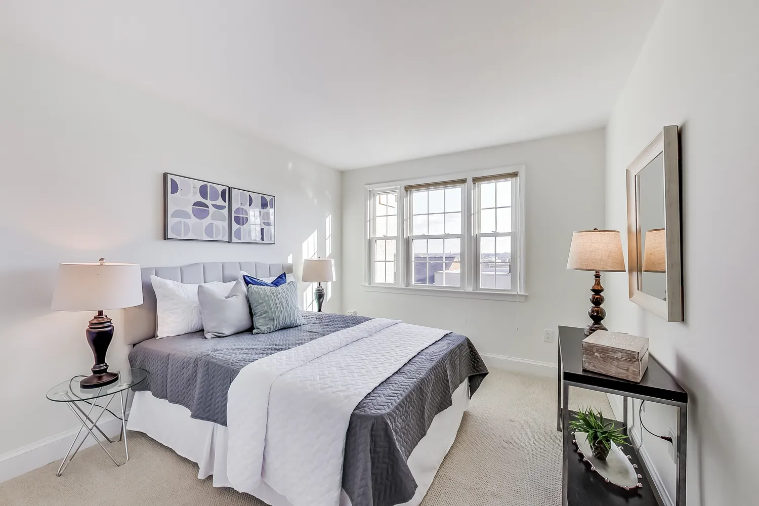 a bedroom with a bed and a large window