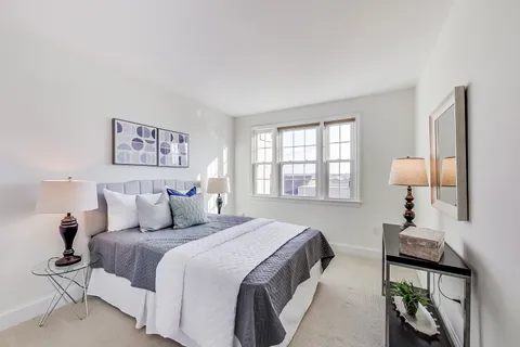 a bedroom with a bed and a large window